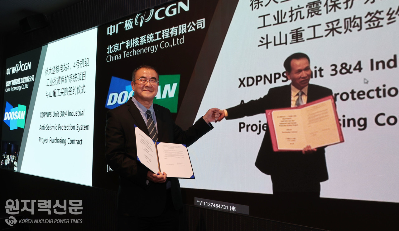 두산중공업 나기용 부사장(왼쪽)과 중국 CTEC 장궈진 사장이 화상으로 계약을 체결한 뒤 주먹 인사를 하고 있다.
