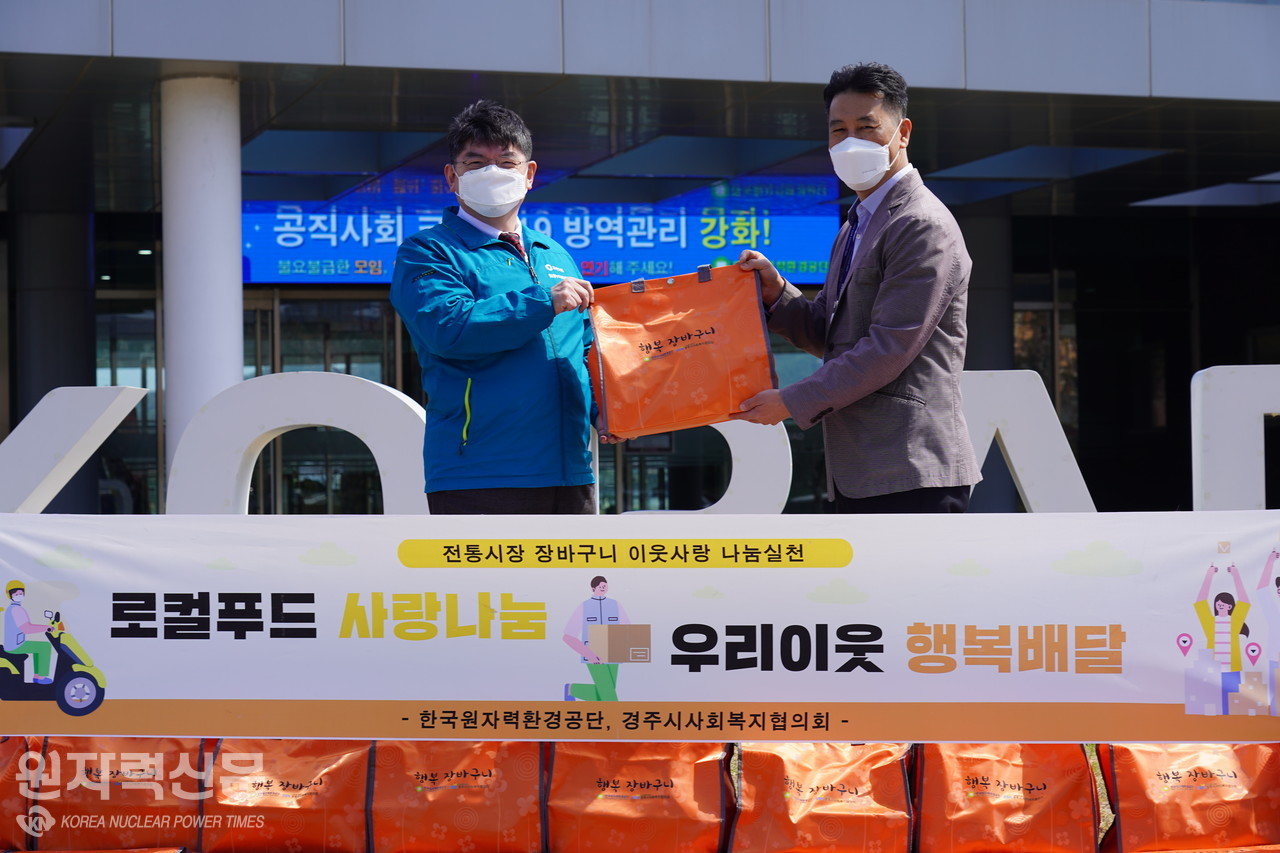 차성수 한국원자력환경공단 이사장(왼쪽)이 김종우 경주시사회복지협의회장에게 행복장바구니를 전달하고 있다.